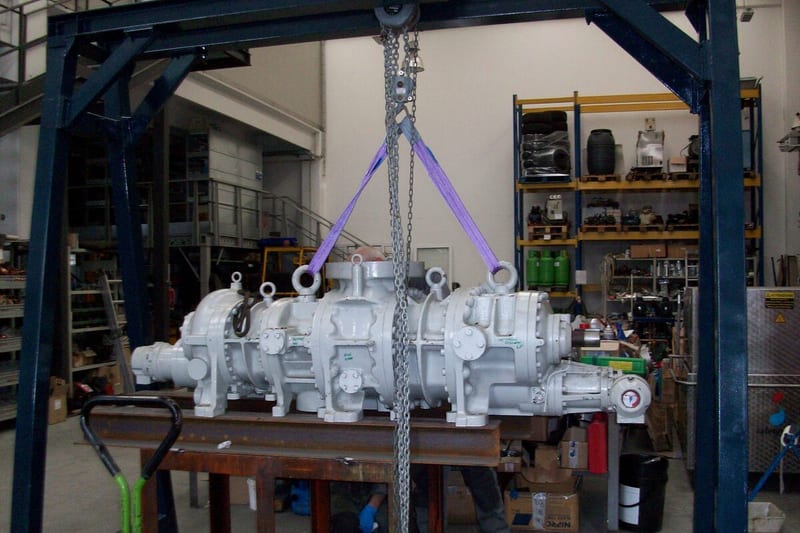 Industrial compressor being lifted in workshop